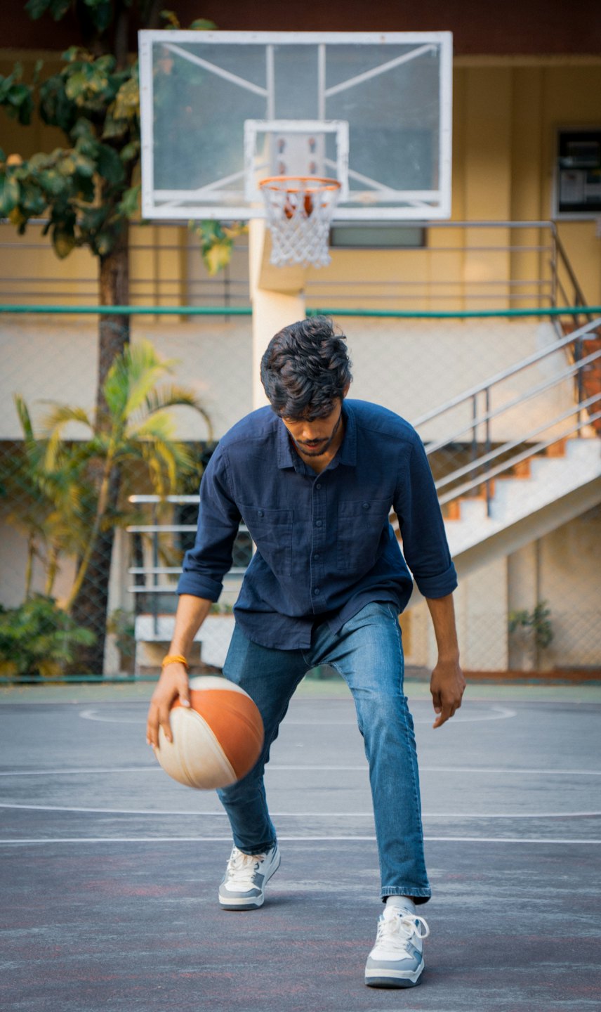 Man dribbles a basketball on an outdoor court.
